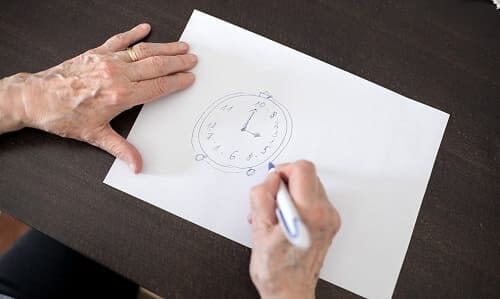 Пожилой человек рисует часы